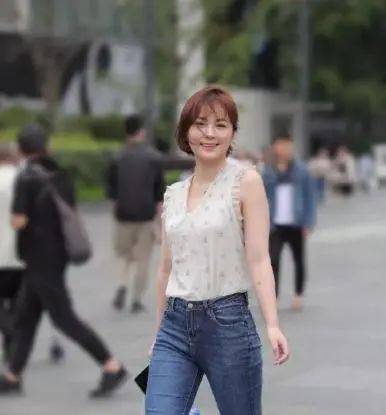 短发美女小衫搭配紧身牛仔裤,散发着迷人的微笑
