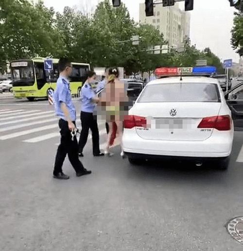 女子大街上边走边脱走猫步,惹起众怒还不自知,民警将其带走