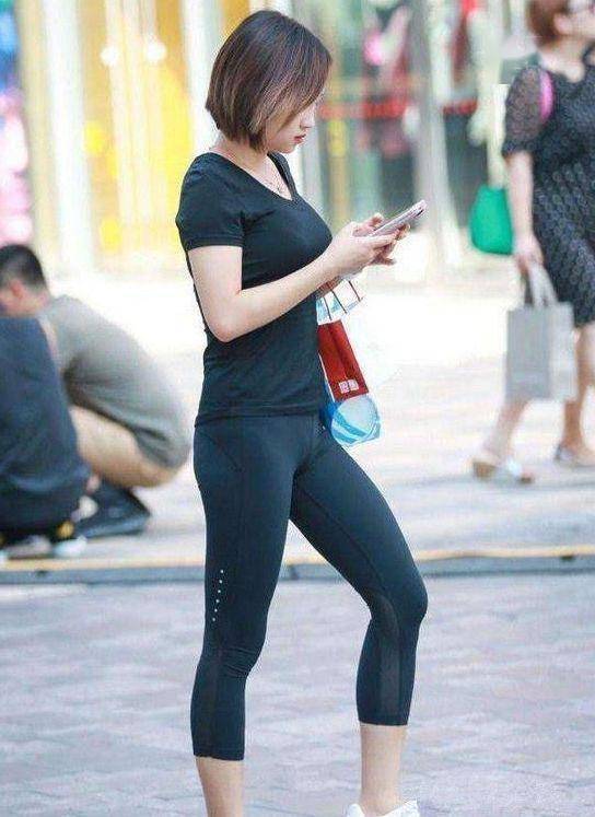 街拍,美女身穿绿色上衣外穿,身材丰满,迎面走来引得路人回头
