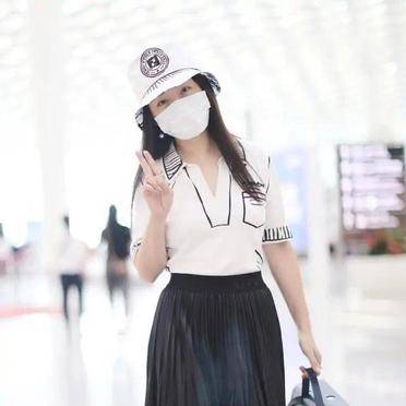 身穿一件白色漫画上衣搭配一条黑色半身裙,少女感十足