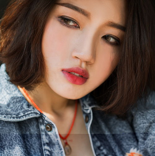 在一处废弃房屋边的短发气质牛仔美女