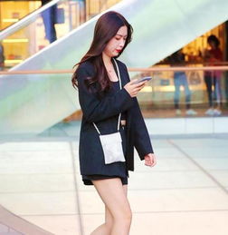街拍皮肤白皙的美女,一件黑色短袖配黑色短裤,时尚青春靓丽