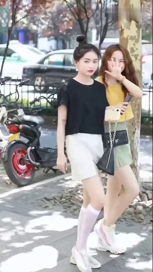 街拍黑衣丸子头美女好高冷,黄衣闺蜜调皮可爱,你喜欢哪一个